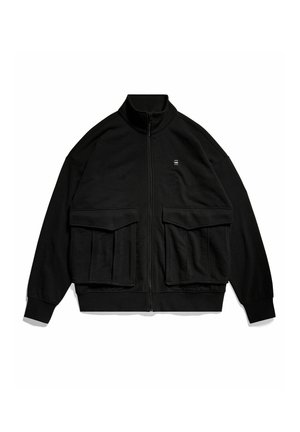 Giacca zip nera con collo alto, grandi tasche frontali e un logo sottile sul petto. Realizzata in un tessuto morbido e testurizzato.