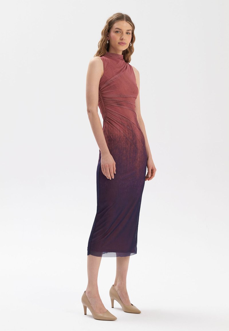 Dopasowana sukienka z wysokim dekoltem, przechodząca od czerwonego wierzchu do głębokiego niebieskiego dołu. Gładka tekstura i szczegóły marszczenia po bokach.