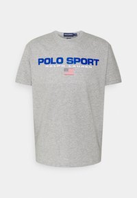 Šedé bavlněné tričko s kulatým výstřihem, krátkými rukávy a modrým nápisem "POLO SPORT" s grafikou americké vlajky pod nápisem.