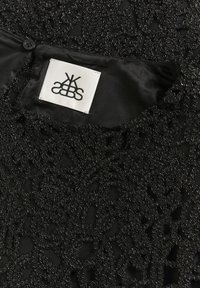Tessuto nero con intricato ricamo di perline nere. Presenta un morbido rivestimento in satin e un'etichetta con un logo stilizzato.