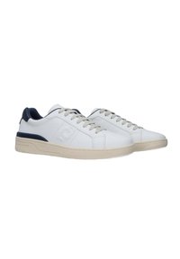Sneakers bianchi in pelle con design a taglio basso, accentuazione del tallone blu navy e suola in gomma color crema. Presentano lacci e un discreto dettaglio del logo sul lato.
