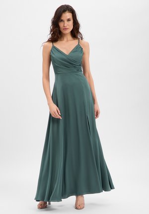 Langes Kleid in tiefem Petrol, aus glattem Stoff. Es verfügt über Spaghettiträger, einen V-Ausschnitt und einen Seitenschlitz für mehr Bewegungsfreiheit.