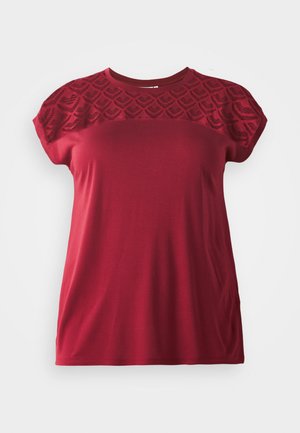 Red short-sleeve t-shirt with a textured, patterned lace yoke. Soft fabric with a relaxed fit, featuring a round neckline and smooth finish.