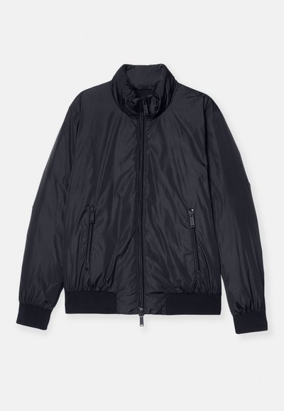 Black padded jacket with a high collar, front zip closure, and two zippered side pockets. Features ribbed cuffs and hem. Smooth, shiny texture.