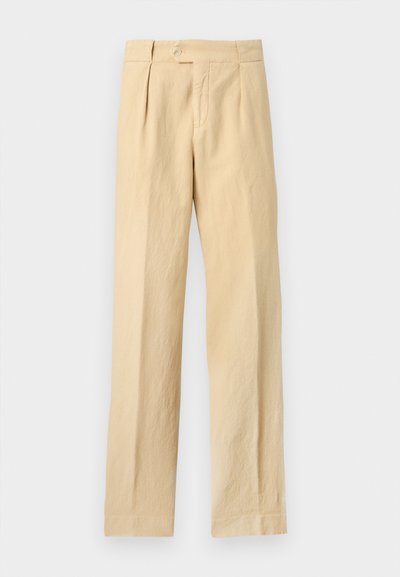 Μπεζ παντελόνι με ίσια γραμμή, κούμπωμα με κουμπί και φερμουάρ, πιέτες μπροστά και πλαϊνές τσέπες, σε απλό φόντο.