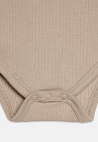 Beige bordázott body, lekerekített nyakkivágással, három patenttal az alján és puha, texturált anyagból.