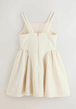 Rochie fără mâneci de culoare crem, cu bretele duble pe umeri, corset mulat, fermoar frontal și fustă evazată adunată.