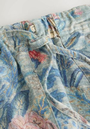 Blue fabric pants with pink and blue floral pattern, featuring an elastic waistband and tied drawstring at the front.