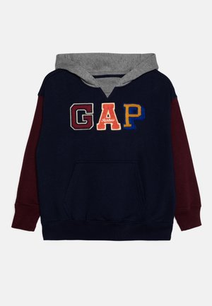 Navyblå hættetrøje med grå hætte, vinrøde ærmer, forlomme og store flerfarvede "GAP" bogstaver på brystet.