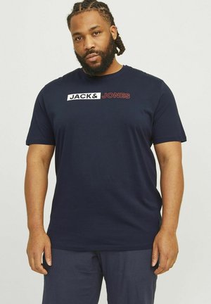 Navy blue cotton t-shirt with short sleeves and crew neck, featuring a white and red logo graphic on the chest. Smooth texture.