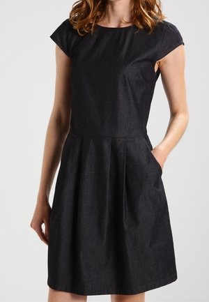Robe en denim noir à manches courtes avec un corsage ajusté, une jupe évasée, des poches latérales et un col épuré, mettant en valeur une texture lisse.