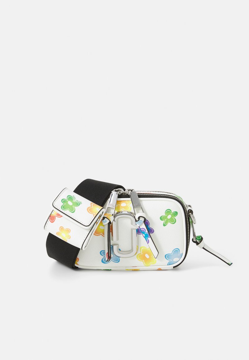Hvid crossbody taske med blomsterprint i flere farver, sølvfarvet hardware og en sort rem. Lynlås lukning og kompakt design.