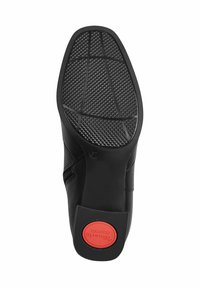 Talpa de pantof negru cu un model texturat pentru aderență. Dispune de un logo circular roșu etichetat "Tomar's Comfort" aproape de călcâi. Margini și formă netedă.