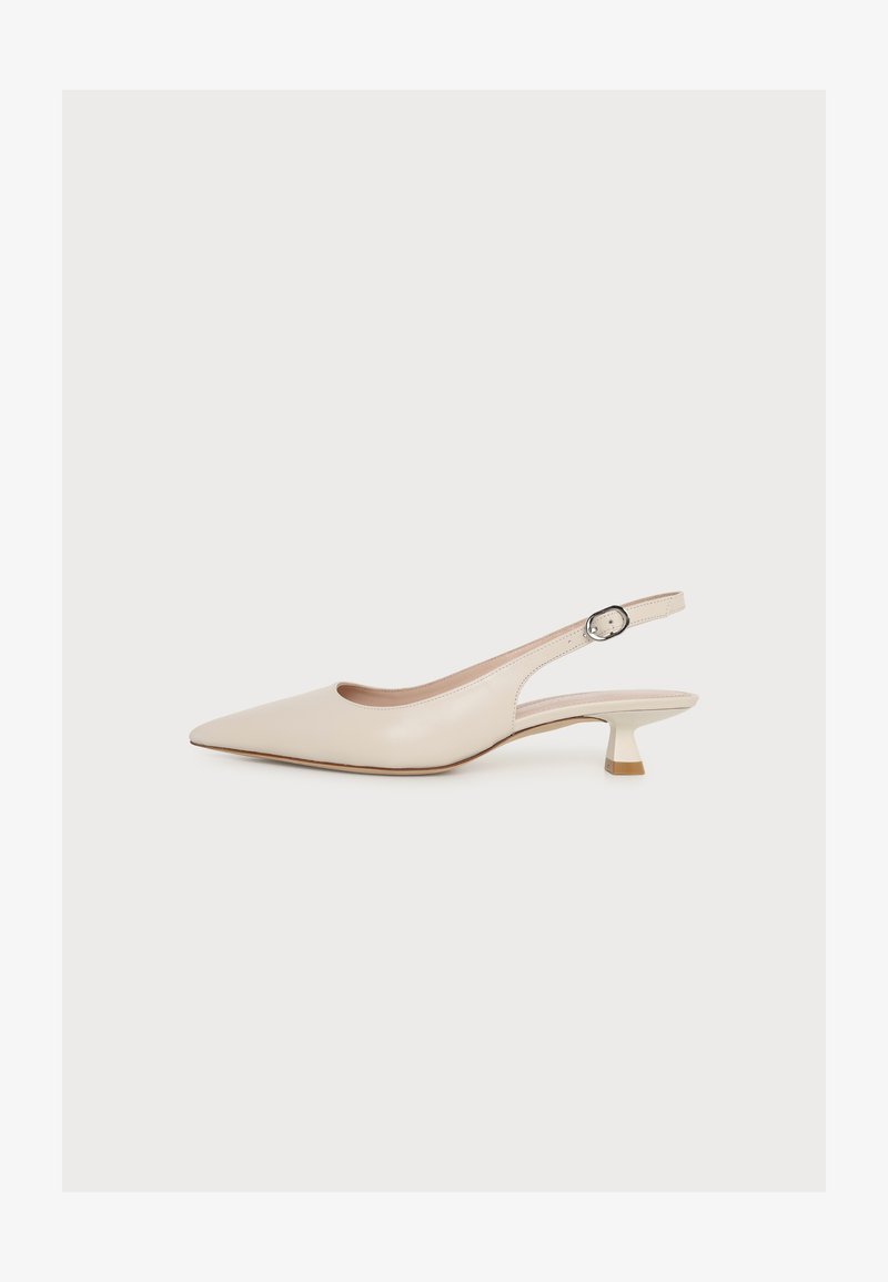 Chaussure slingback beige à bout pointu avec un petit talon kitten et une bride cheville avec une petite boucle, présentée sur un fond blanc uni.