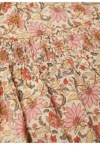 Blumenmusterstoff in Rosa-, Gelb- und Grüntönen mit strukturierter Oberfläche und gerafftem Detail, auf einem cremefarbenen Hintergrund.