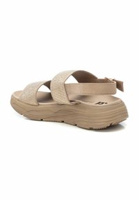 Sandalia beige con tiras cruzadas que presentan acentos de strass, plantilla texturizada y suela gruesa. Correa trasera ajustable para un ajuste seguro.