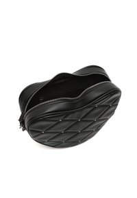 Borsa in pelle nera trapuntata, forma rotonda con borchie in metallo, chiusura con zip superiore, foderatura visibile e superficie testurizzata.