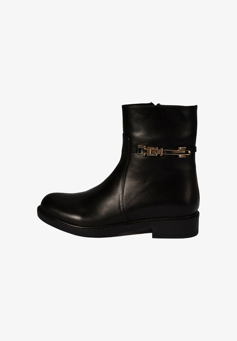 Bottine en cuir noir avec une texture lisse, bout arrondi, petit talon carré et un accent chaîne de couleur dorée autour de la cheville.