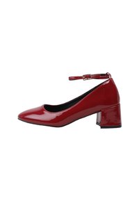 Chaussure à talon bas en cuir verni rouge avec un bout pointu et une fine bride ajustable à la cheville avec boucle.