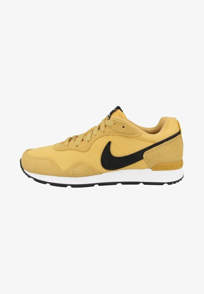 Chaussure de course jaune Nike avec logo swoosh noir, semelles intermédiaires blanches et semelles extérieures noires, vue de côté.