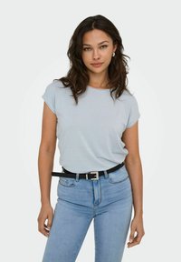 Camisa azul clara de manga corta con un corte holgado y rayas sutiles, combinada con jeans azul claros de tiro alto y un cinturón negro con hebilla plateada.