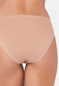 Beige naadloze katoenen slipjes met elastische tailleband, een gladde textuur en zonder zichtbare naden, ontworpen voor comfort en discreet dragen.