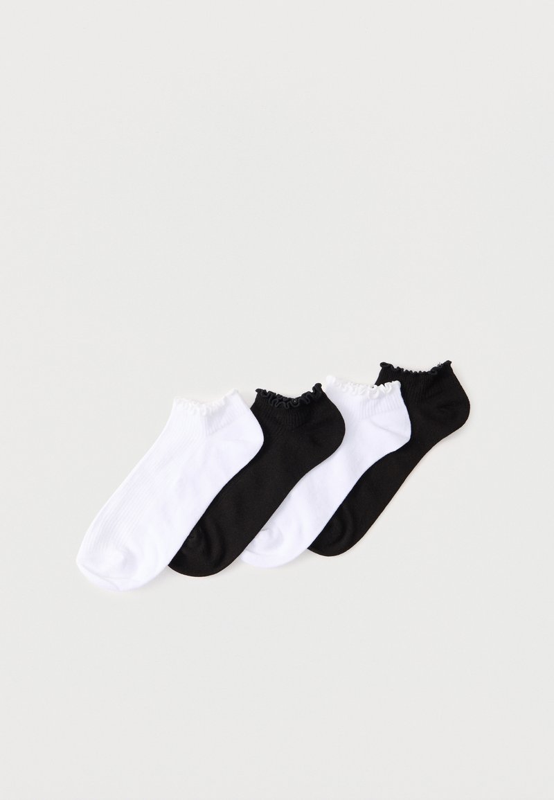Deux paires de chaussettes basses à bords froncés, une paire blanche et une paire noire, disposées en alternance sur un fond clair.
