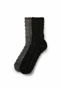 Kabelstrick-Socken mit einem grauen und einem schwarzen Halbteil, aus einem dicken, strukturierten Stoff für Wärme gefertigt. Knöchelhöhe mit gerippten Bündchen.