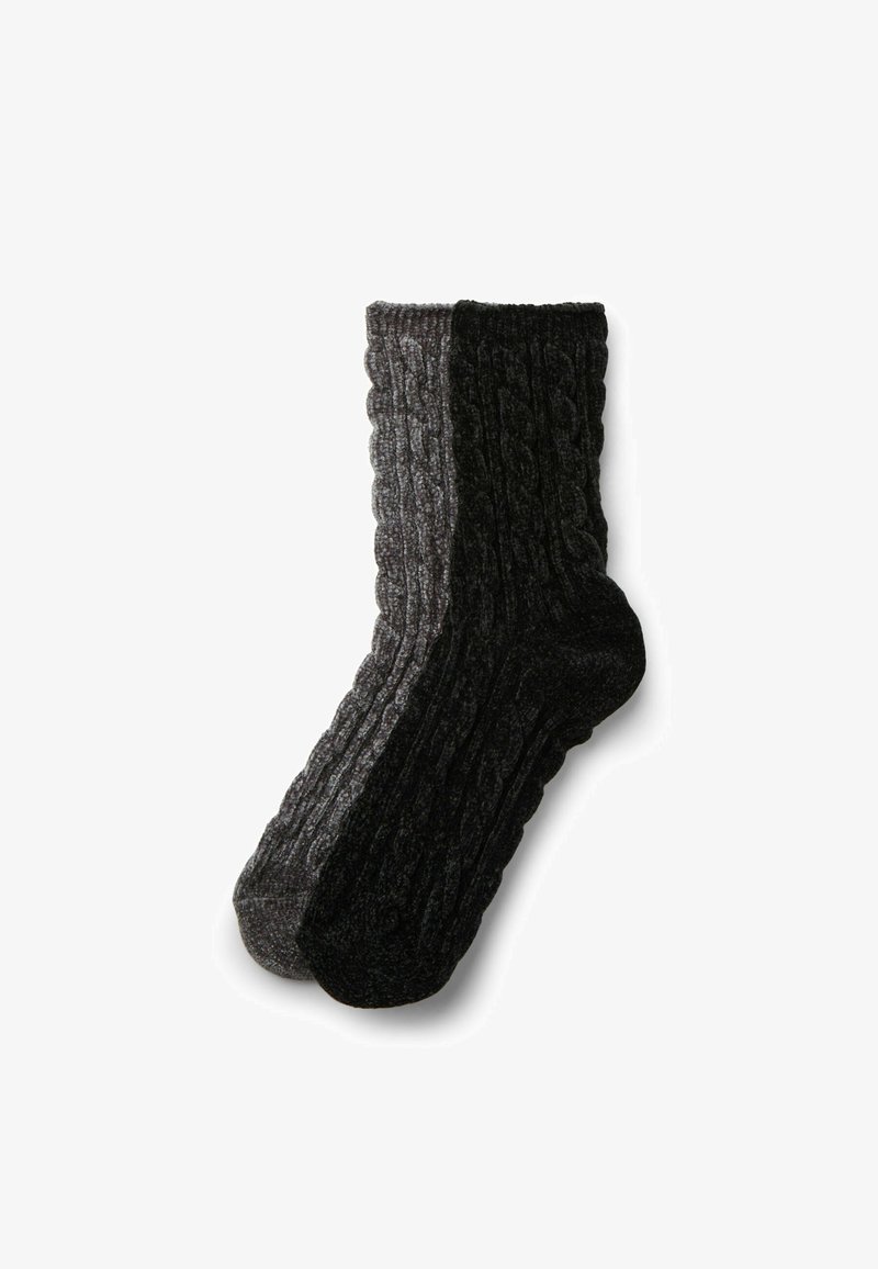 Kabelstrick-Socken mit einem grauen und einem schwarzen Halbteil, aus einem dicken, strukturierten Stoff für Wärme gefertigt. Knöchelhöhe mit gerippten Bündchen.