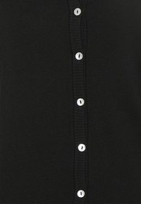 Svart cardigan med ribbad textur, prydd med rund, silverfärgade knappar fram. Klassisk design och mjukt tyg.