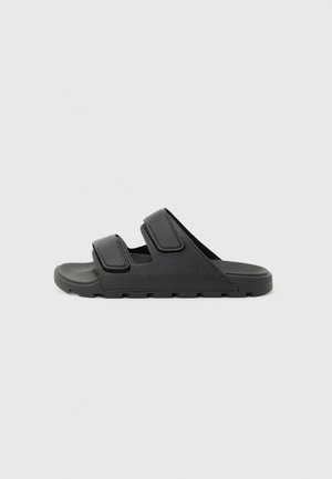 Sandaletto nero con due ampi cinturini regolabili e suola texturizzata, progettato per un uso casual.