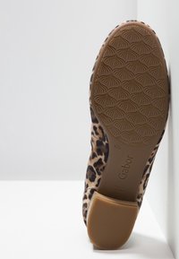 Ballerines à imprimé léopard avec une tige en daim, une semelle en caoutchouc et un motif texturé ; arbore la marque Gabor embossée sur la semelle.