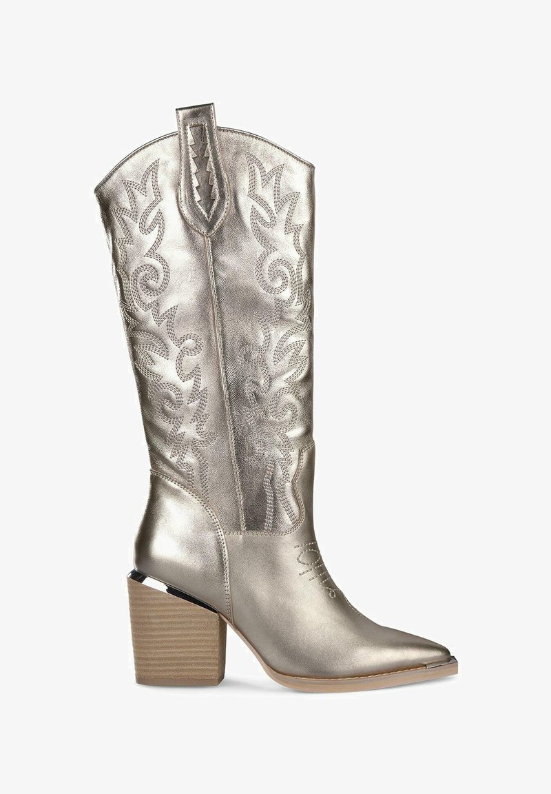 Metallisch zilveren cowboylaars met een puntige neus en een gestructureerde schacht. Beschikt over ingewikkelde decoratieve stiksel en een robuuste, houten hak.