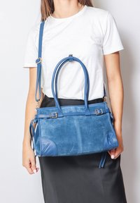 Borse in pelle scamosciata blu con due manici e una tracolla rimovibile. Presenta una forma strutturata e dettagli di cucitura a vista.