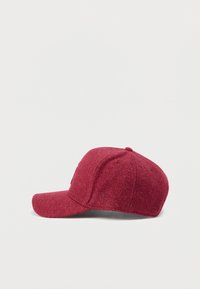 Gorra roja de fieltro con visera curva, que presenta una tela texturizada y un logo bordado en el lateral. Diseñada para un estilo ajustado.