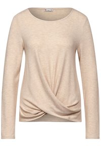 Beige pitkähiha-paita, joka on valmistettu pehmeästä neuloksesta. Siinä on pyöreä pääntie ja etuosassa kierretty yksityiskohta, joka luo laskeutuvan efektin helmaan.