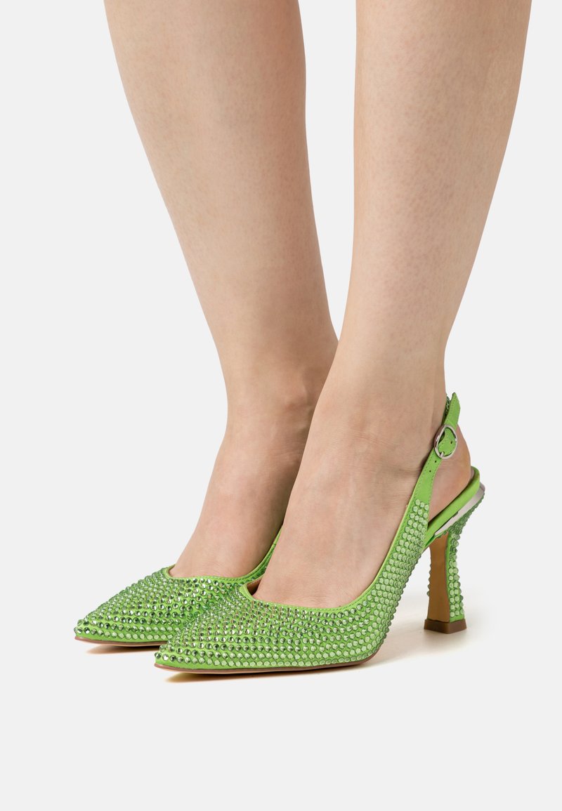 Sapatos de salto alto em verde, com apontados, tipo slingback, adornados com strass. A superfície texturizada e o salto transparente e esbelto criam um design ousado.