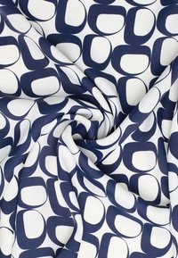 Navy and white patterned fabric featuring overlapping abstract shapes with a smooth texture, arranged in a swirling motion.