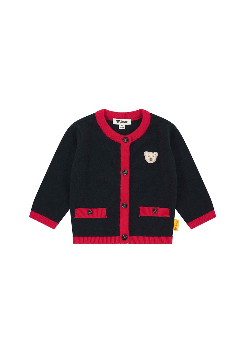 Cardigan nero per bambini con rifiniture rosse, bottoni neri, due tasche frontali e un piccolo patch di un orsetto beige sul petto.