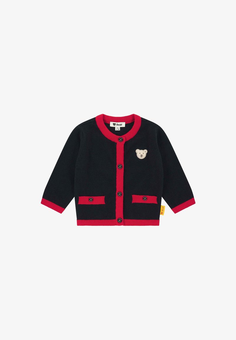 Cardigan nero per bambini con rifiniture rosse, bottoni neri, due tasche frontali e un piccolo patch di un orsetto beige sul petto.