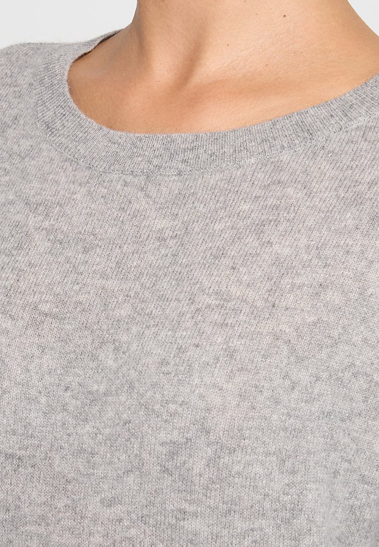 Grijze gebreide trui met een ronde halslijn, zachte textuur en subtiele kleurvariaties, die een lichtgewicht, casual ontwerp toont.