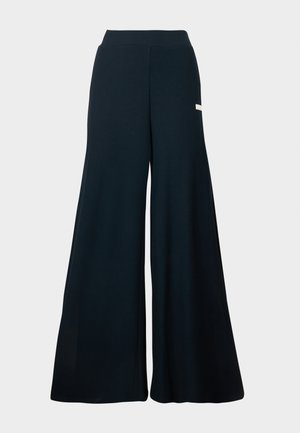 Wide-leg trousers in dark blue ribbed fabric, featuring a high waistband and subtle side branding detail. Smooth texture and full length.