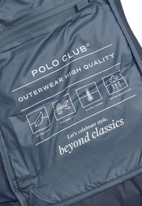 Mörkblå, vattentålig tyg med en slät yta; har vit märkning och ikoner för ultralätt, skräddarsydd passform och värmespecifikationer.