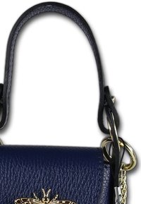 Kleine marineblauwe leren handtas met een gestructureerd oppervlak, gouden hardware en een decoratieve bijaccent aan de voorkant. Inclusief een handvat bovenop en een kettingband.