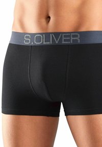 Crne bokserice od rastezljivog materijala, sivo elastično pojas s logotipom "S. OLIVER" otisnutim u srebrnoj boji.