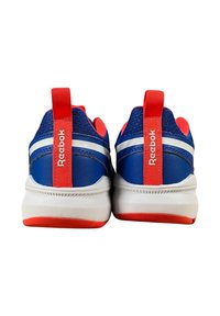 Un paio di sneakers Reebok blu e rosse viste da dietro, con strisce bianche e linguette rosse con il nome del marchio.