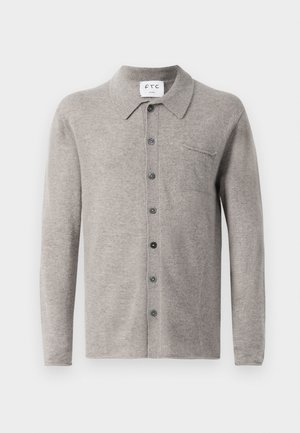 Grauer gestrickter Cardigan mit Kragen, siebenknöpfigem Verschluss und einer Brusttasche. Er zeichnet sich durch eine weiche Textur und ein dezentes Muster aus.