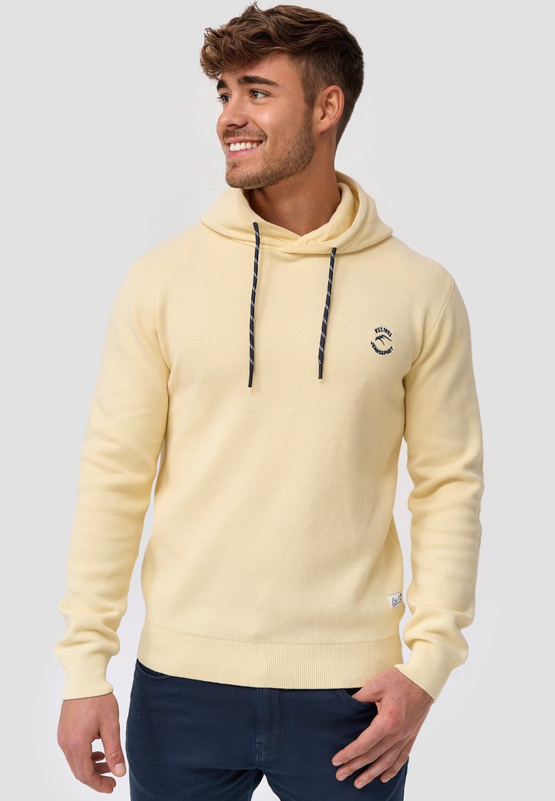 Sudadera tipo pullover en tela de color amarillo claro, con capucha ajustable mediante cordón, puños y dobladillo acanalados, y un pequeño logo bordado en el pecho.