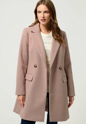 Dobbeltradet frakke i blødt pink stof med store revers, to forlommer og dekorative guldknapper. Tekstilstrikket sweater underneath.