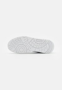 Semelle de chaussure en caoutchouc blanc avec motifs de préhension texturés et accents circulaires, comportant un logo de marque embossé près du talon.